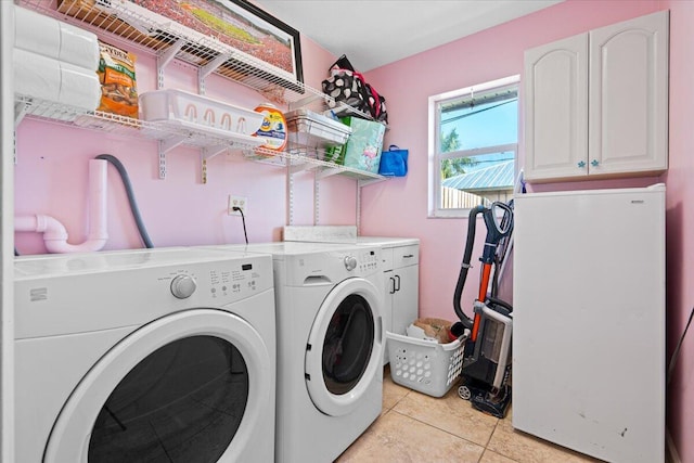 laundry area featuring light tile patterned flooring, separate washer and dryer, and cabinets