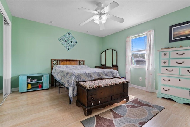 bedroom with ceiling fan, light wood-type flooring, and a closet