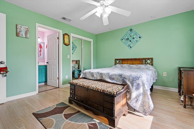 bedroom featuring ceiling fan, light hardwood / wood-style flooring, connected bathroom, and a closet