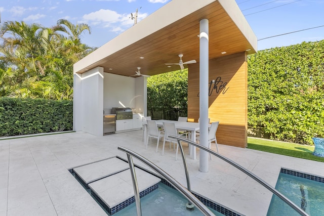 view of pool with ceiling fan, a grill, a patio, and an outdoor kitchen