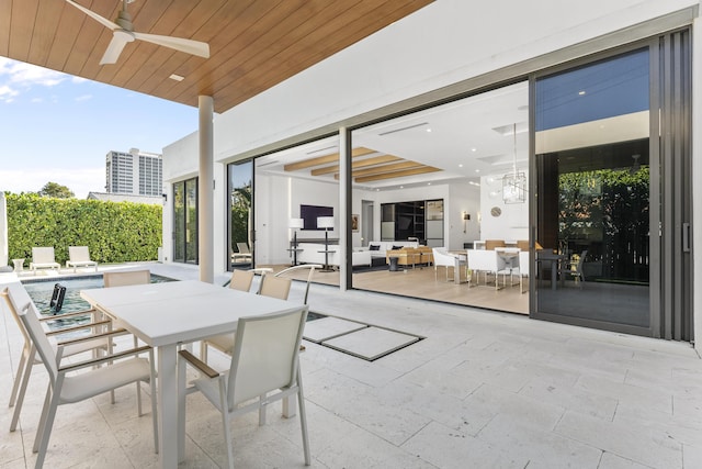 view of patio with ceiling fan and a swimming pool