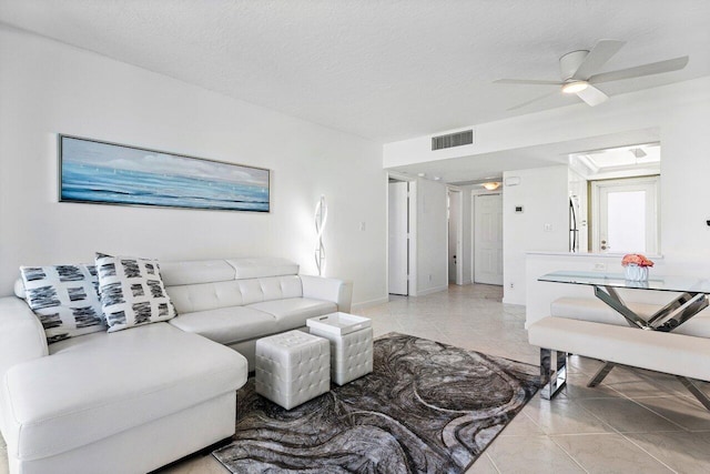 tiled living room featuring a textured ceiling and ceiling fan