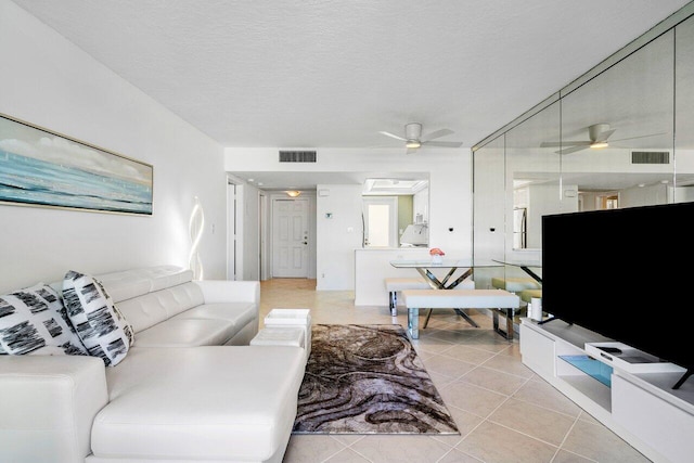 tiled living room featuring ceiling fan and a textured ceiling