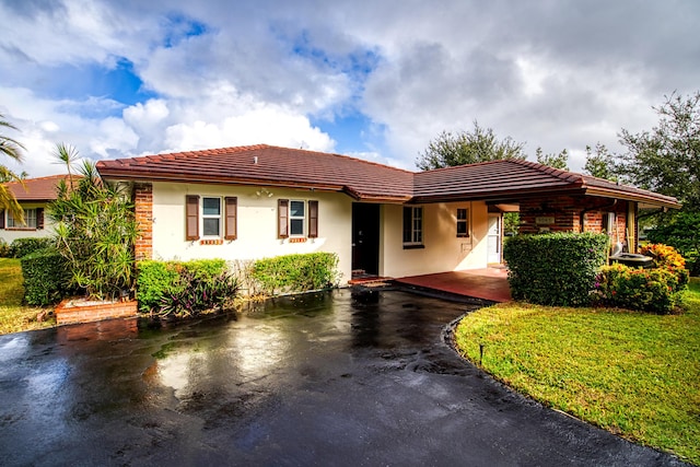 view of front facade featuring a front yard and a carport