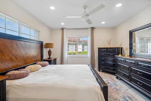 bedroom featuring ceiling fan, light tile patterned flooring, and multiple windows