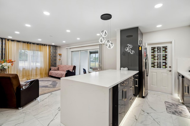 kitchen featuring pendant lighting, stainless steel fridge, a kitchen island, and a wealth of natural light