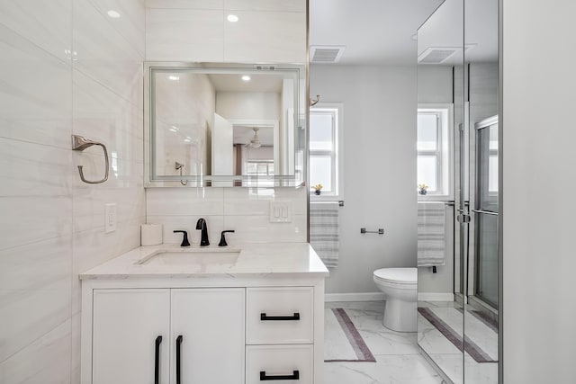 bathroom with vanity, toilet, and a shower with door