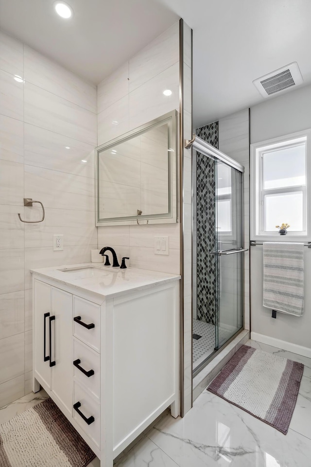 bathroom featuring tile walls, vanity, and an enclosed shower