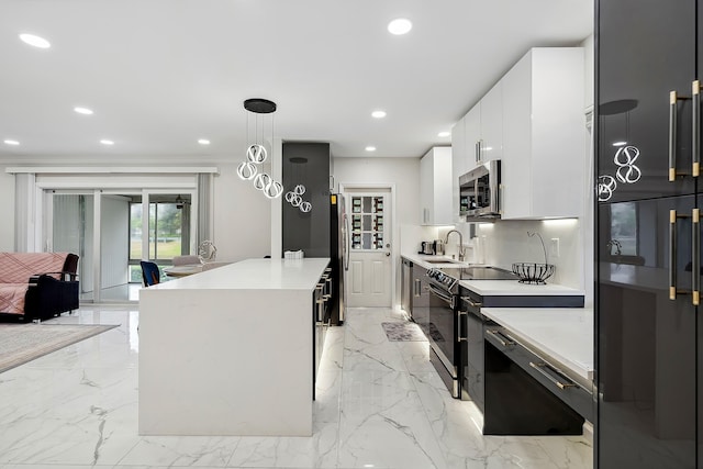 kitchen with sink, hanging light fixtures, stainless steel appliances, a kitchen island, and white cabinets