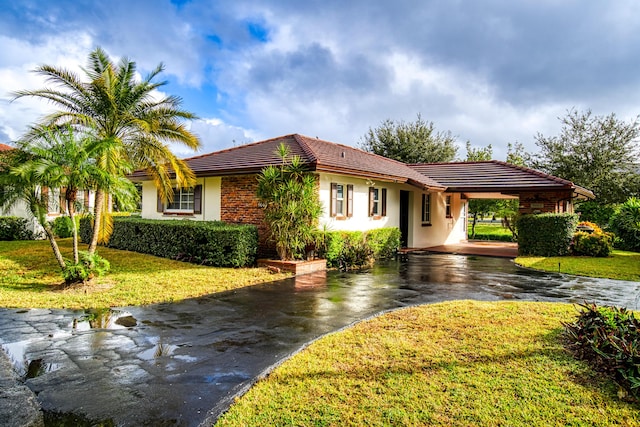 view of front of house featuring a carport and a front lawn