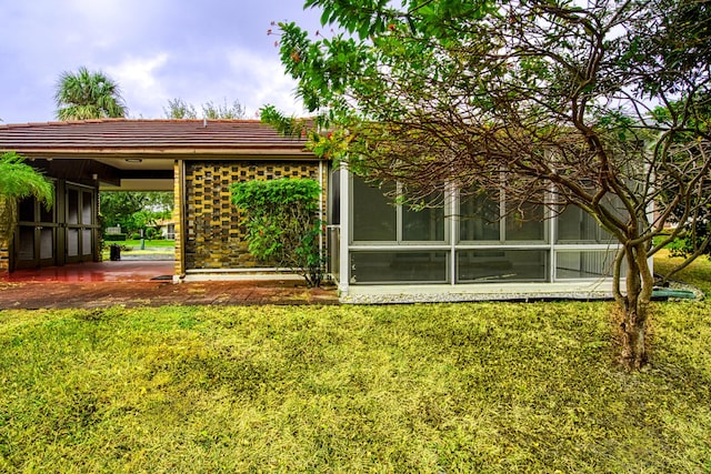 rear view of property with a sunroom and a yard