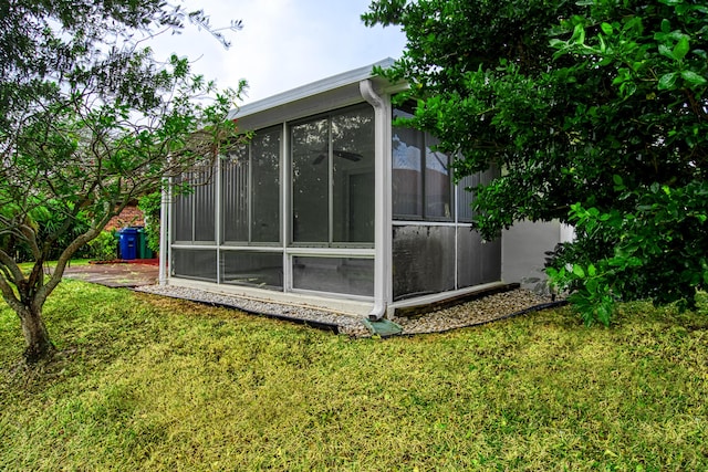 view of property exterior featuring a lawn and a sunroom