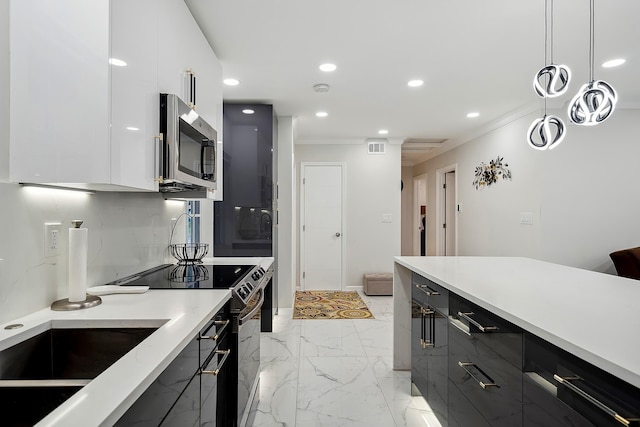 kitchen with pendant lighting, stainless steel appliances, white cabinetry, and ornamental molding