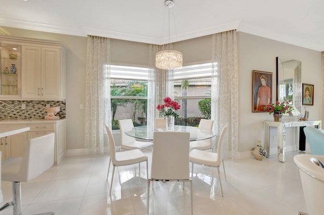 tiled dining room featuring an inviting chandelier and crown molding