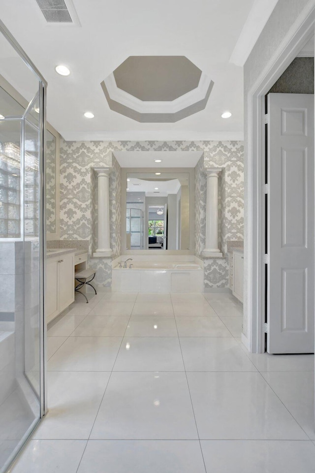 hallway with decorative columns, crown molding, a tray ceiling, and light tile patterned flooring