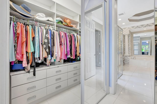 walk in closet with light tile patterned floors and decorative columns