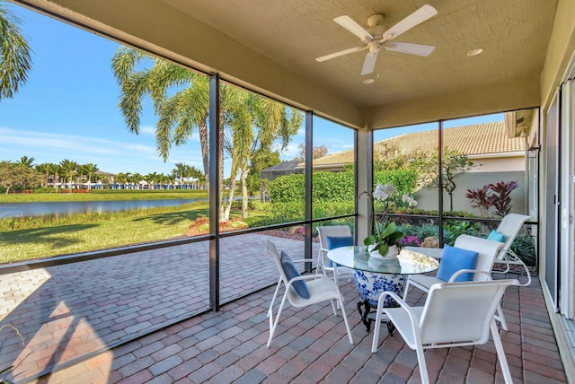 sunroom / solarium featuring a water view and ceiling fan