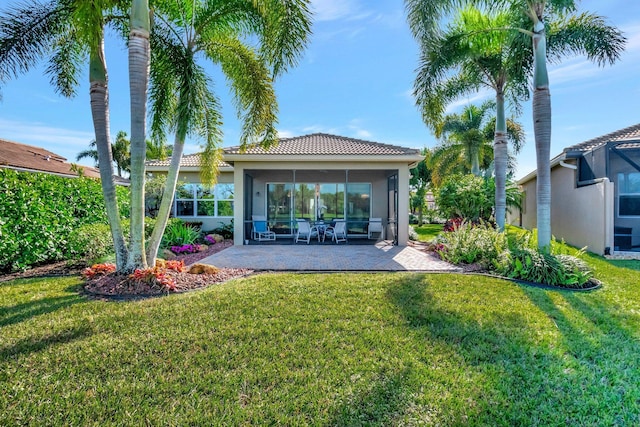 back of house with a sunroom, a patio, and a lawn