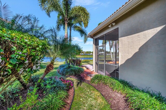 view of yard featuring a water view and a sunroom