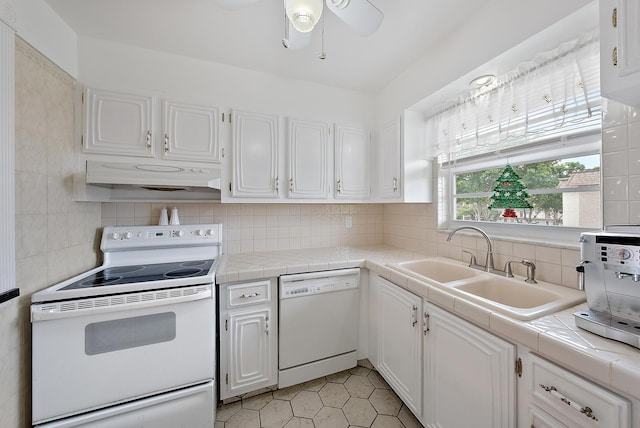 kitchen with white appliances, tile countertops, and white cabinets