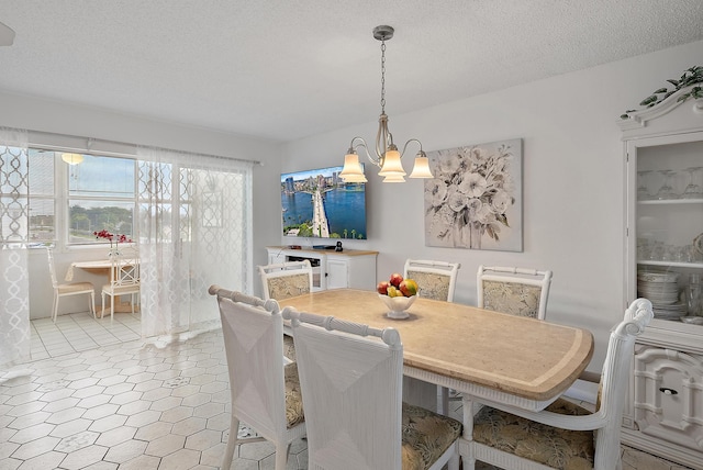 dining space featuring a notable chandelier and a textured ceiling