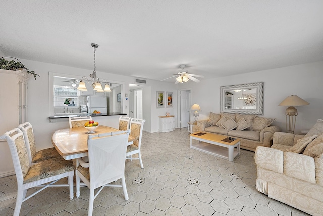 dining area featuring ceiling fan with notable chandelier