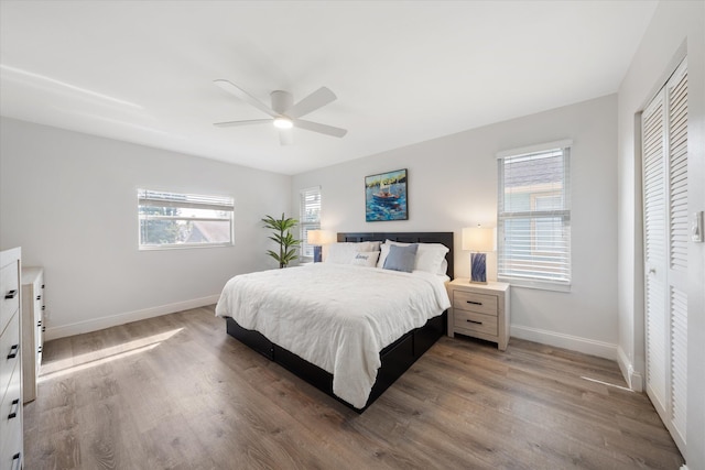 bedroom with hardwood / wood-style floors, a closet, and ceiling fan