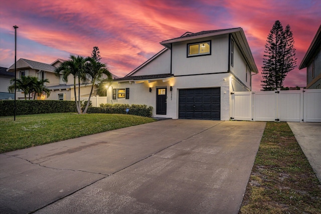 view of front of property with a garage and a lawn