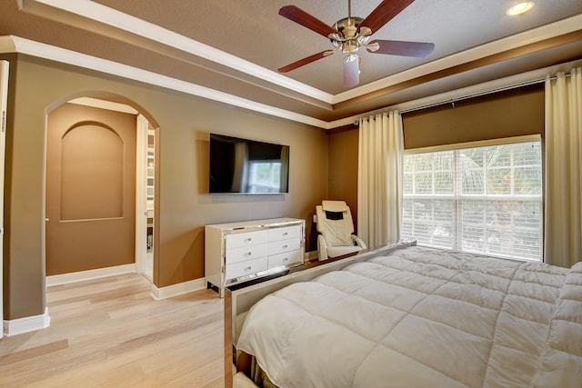 bedroom featuring a textured ceiling, light hardwood / wood-style floors, ceiling fan, and crown molding