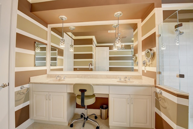 bathroom featuring a tile shower, tile patterned flooring, and vanity