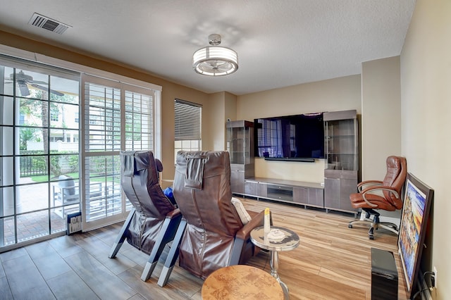 living room with wood-type flooring and a textured ceiling