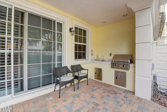 view of patio featuring an outdoor kitchen, grilling area, and sink