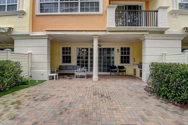 exterior space featuring ceiling fan, a patio area, a balcony, and an outdoor living space