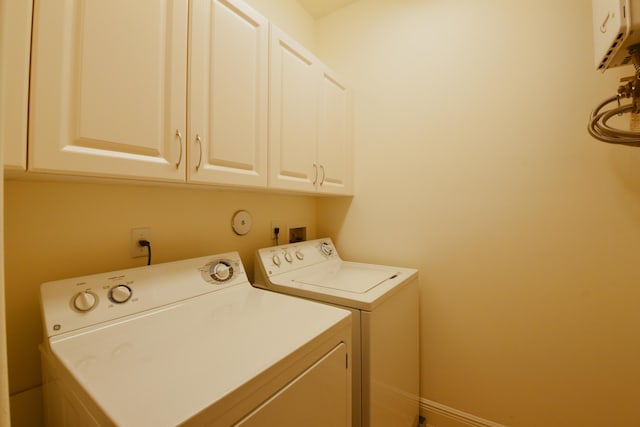 laundry area featuring washer and clothes dryer and cabinets