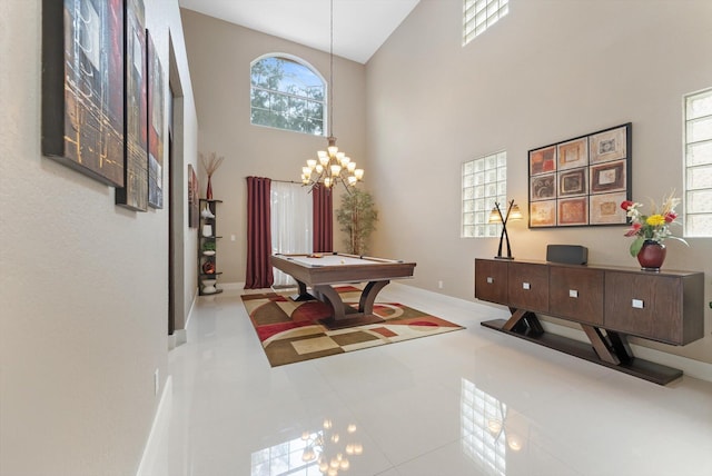 recreation room featuring light tile patterned floors, a towering ceiling, pool table, and an inviting chandelier