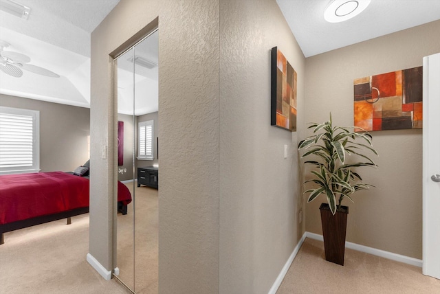 hallway featuring light colored carpet