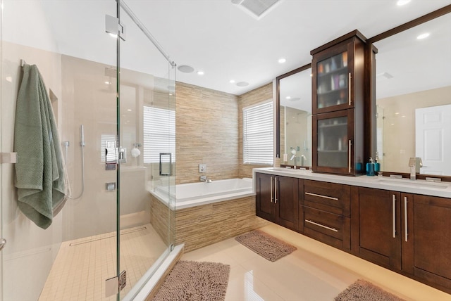 bathroom featuring tile patterned flooring, vanity, and shower with separate bathtub