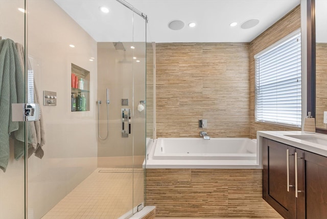 bathroom featuring vanity, tile walls, and independent shower and bath