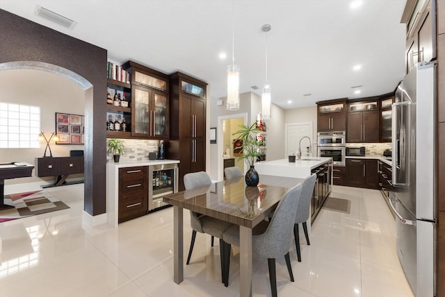 tiled dining space featuring wet bar and beverage cooler