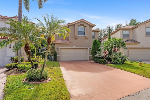 mediterranean / spanish home featuring a front yard and a garage