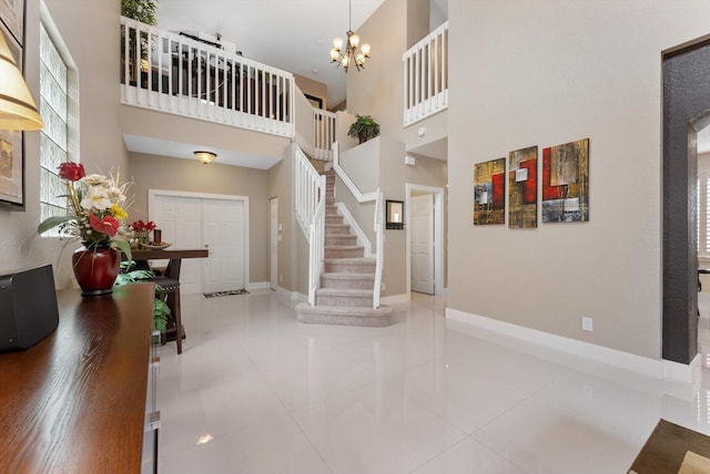 tiled entryway featuring a high ceiling and a notable chandelier