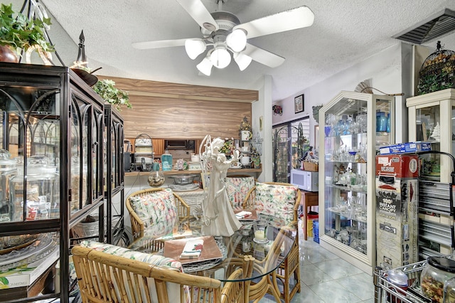 dining space with ceiling fan, light tile patterned floors, and a textured ceiling