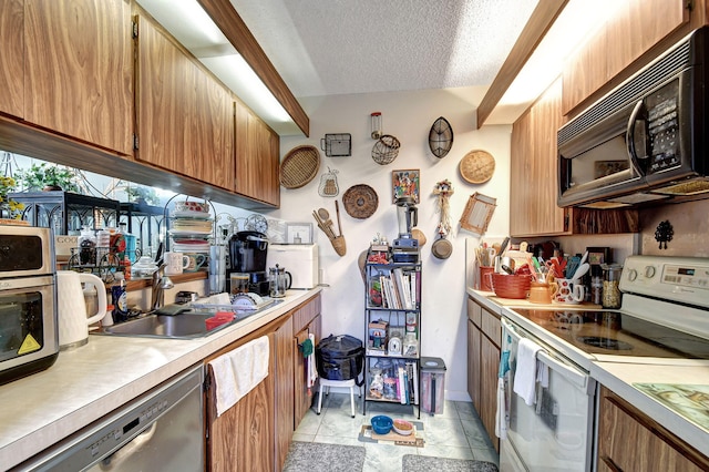 kitchen featuring sink, stainless steel dishwasher, light tile patterned floors, a textured ceiling, and white range with electric stovetop