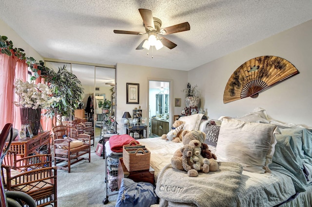 carpeted bedroom featuring ceiling fan, a closet, a textured ceiling, and ensuite bath