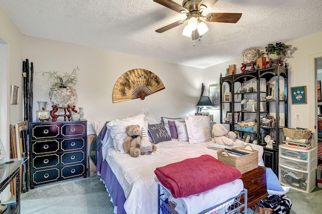 carpeted bedroom with ceiling fan and a textured ceiling