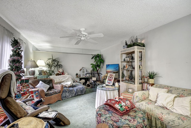 living room featuring ceiling fan, carpet floors, and a textured ceiling