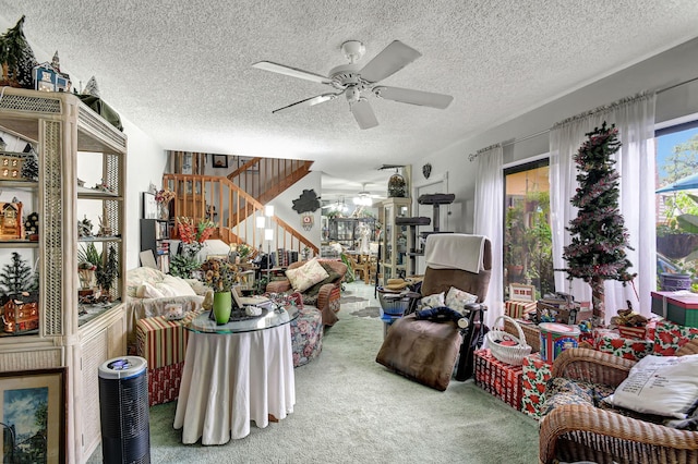 carpeted living room featuring ceiling fan and a textured ceiling