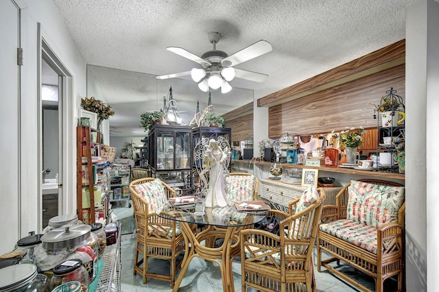 tiled dining room with ceiling fan and a textured ceiling