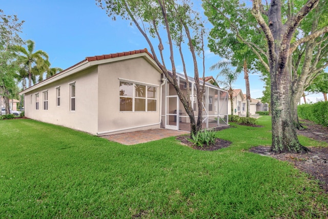 back of property with a patio area and a lawn