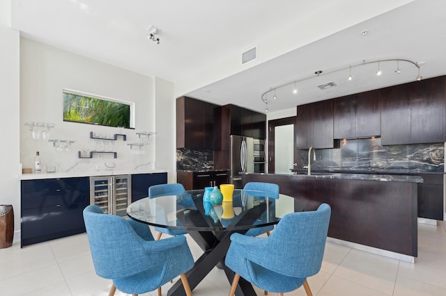 tiled dining room featuring sink, beverage cooler, and track lighting